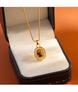 Détail macro du collier pendentif œil de tigre ovale avec zircons scintillants