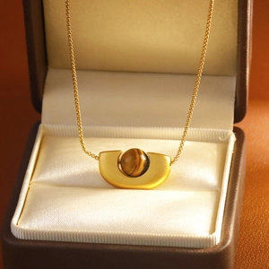 Collier doré élégant avec pendentif oeil de tigre sur doublure en satin blanc
