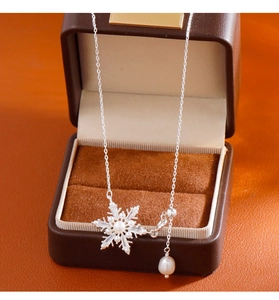 Dettaglio collana fiocco di neve in argento con perla e zirconi su custodia in pelle
