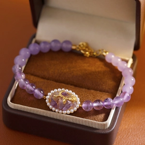 Elegante pulsera de amatista natural con rosa dorada en una caja de regalo joya