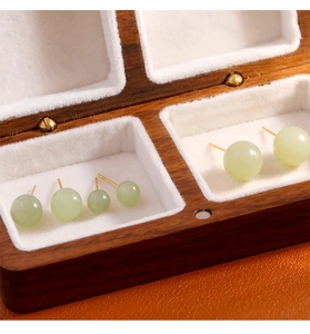 Vue détaillée de boucles d'oreilles en jade vert clair de tailles variées sur velours