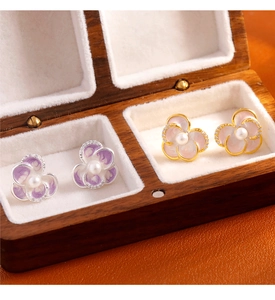 Detail of floral enamel earrings with pearls and crystals in a wooden jewelry box
