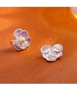 Macro detail of enamel flower stud earrings with pearl centers and S925 silver posts