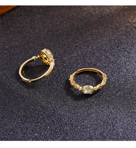 Close-up of vintage gold ring with moonstone and intricate carved details on black base