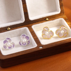 Enamel flower stud earrings with pearl centers and micro-diamonds in a jewelry box