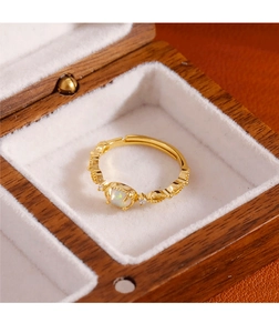 Detail of adjustable gold ring with opal stone and vintage lace engraving in a jewelry box