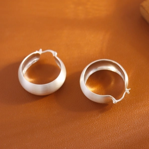 Créoles en argent sterling brossé avec poinçon S925 sur fond en cuir marron