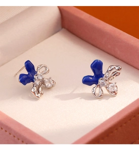 Vista macro de pendientes de mariposa en esmalte azul con marco de plata y cristales