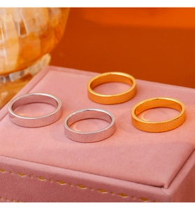 Macro shot of 18k gold and silver plated textured rings on a pink velvet jewelry box