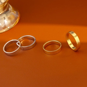 Minimalist 18k gold and silver plated textured stackable rings on premium leather background