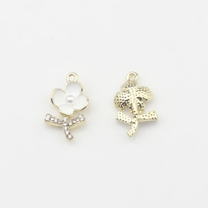 Vue détaillée d'un pendentif fleur avec émail blanc, perle centrale et strass brillants