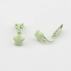 Detail van mintgroene matte ster oorclip voor oren zonder gaatjes op witte achtergrond