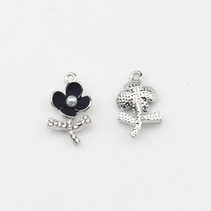 Vue détaillée d'un pendentif fleur en émail noir avec perle et strass brillants