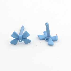 Detailed view of matte sky blue bow-shaped DIY jewelry charms with fine hanging holes