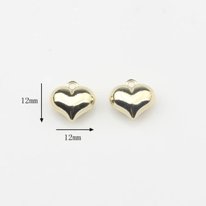Vista detallada de mini dijes de corazón dorados de 12 mm para crear joyas DIY