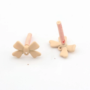 Detail of matte apricot bow charm with bottom loop for DIY earring making craft