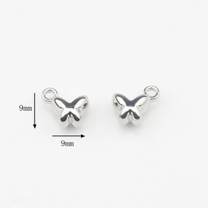 Foto macro de colgantes de mariposa plateados pulidos, tamaño 9mm para joyería artesanal