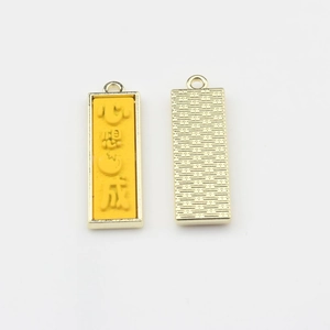 Vue détaillée d'un pendentif en alliage doré avec émail jaune et caractères porte-bonheur