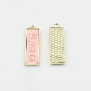 Détail des pendentifs en émail rose avec bordure dorée pour la création de bijoux