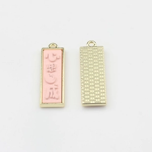 Vue détaillée recto-verso de pendentifs porte-bonheur chinois en résine rose et métal
