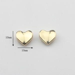Detalle de cuentas metálicas doradas de 10 mm en forma de corazón para joyas