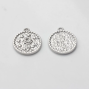 Detailed view of silver alloy coin pendants with embossed rose star and hammered texture