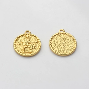Macro view of gold round coin pendants with embossed flower and star pattern texture