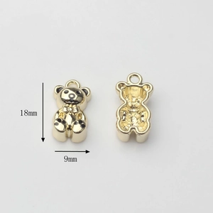 Detailed view of 18x9mm golden metal bear pendants with front and back design
