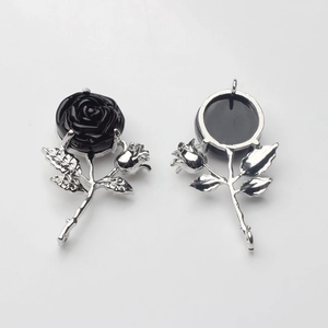 Détail de pendentifs roses argentés avec zircon noir et boucles de suspension