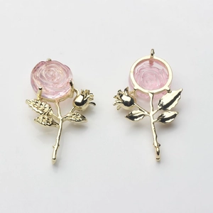 Vue détaillée du pendentif rose avec fleur en résine rose et tige en métal doré poli
