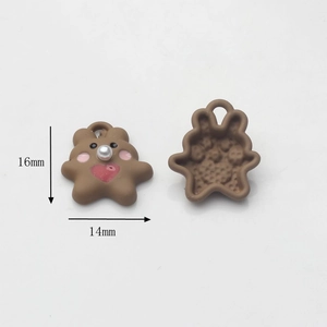 Detail view of cute resin bear charms with pink cheeks, white pearls, and red hearts