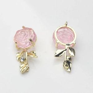 Makro-Detail von Rosenanhängern aus Legierung mit rosa Harzblüten und Zirkon-Goldblättern