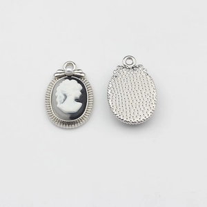 Macro detail of vintage oval relief lady pendant with small pearl accent for DIY jewelry