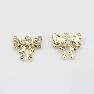 Detalle de colgantes de lazo dorados con circón de corazón y cristales pavé brillantes