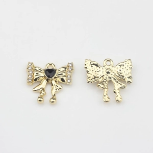 Detalle frontal y posterior del colgante de lazo dorado con corazón negro y cristales