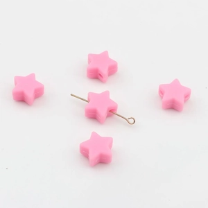 Gros plan de perles en silicone roses en forme d'étoile avec trous centraux pour le DIY