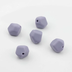 Vista macro de cinco cuentas de silicona lila facetadas para manualidades y joyería DIY
