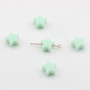 Détail macro de perles en silicone vert menthe en forme d'étoile avec trou horizontal percé