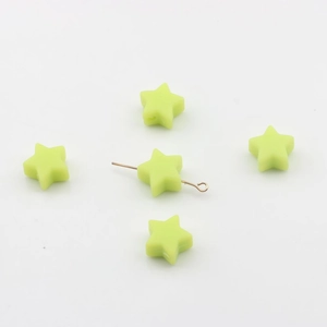 Détail macro de perles étoiles vert fluo de 14mm avec tige dorée montrant le trou DIY