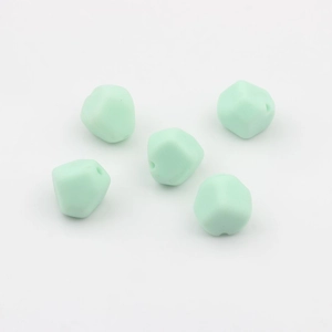 Foto macro de cuentas de silicona poligonales verde menta con agujeros para joyería DIY