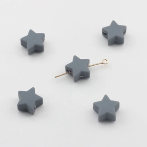 Vue macro de perles en silicone en forme d'étoile grise montrant des trous horizontaux