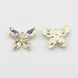 Macro-opname van gouden vlinderbedeltjes met paarse kristallen voor DIY-sieraden maken