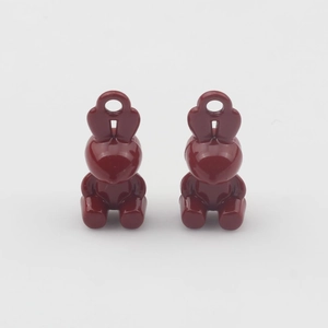 Macro view of two deep red rabbit-shaped charms with polished finish for DIY jewelry