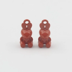 Macro shot of a pair of cute rabbit-shaped alloy pendants with deep red oil dripping finish