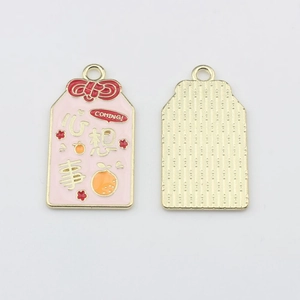 Detailed macro view showing both sides of a pink enamel lucky charm pendant with gold plating