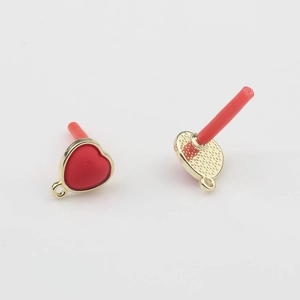 Detailed view of red heart pearl earrings with gold trim and textured back design