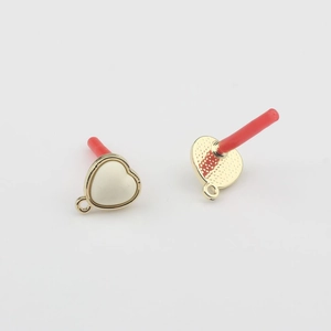 Macro view of heart-shaped pearl enamel charms with gold trim and loop for DIY jewelry