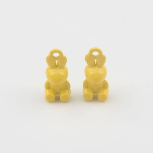 Close-up of two yellow enamel 3D rabbit charms for DIY jewelry making accessories