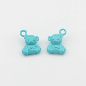 Macro-opname van blauwe beer-bedeltjes met strikjes voor het maken van sieraden