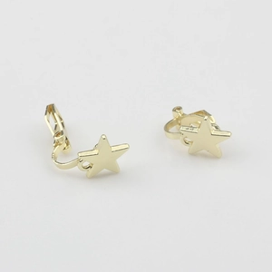 Détail macro de boucles d'oreilles clips étoile dorée avec fermoir à ressort